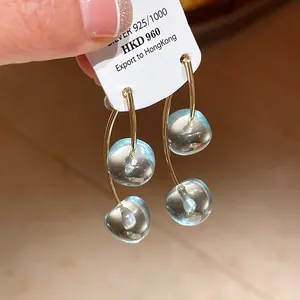 Detail shot of transparent light blue cherry resin earrings with S925 silver needles.
