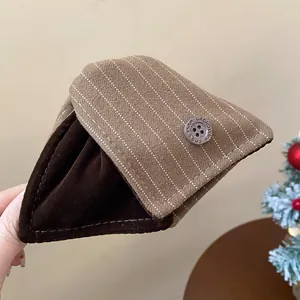 Gros plan d'une pince à cheveux triangulaire rayée marron avec doublure velours