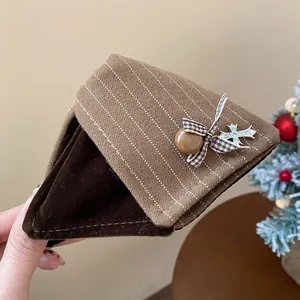 Gros plan sur la grande pince à cheveux triangulaire rayée avec nœud et pendentif.