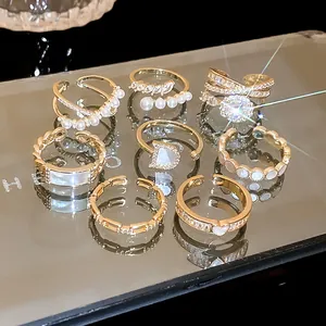 Close-up of elegant gold ring set featuring zircon, pearls and unique shell designs