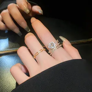 Detail view of elegant gold oval zircon open ring and minimalist chain ring on hand