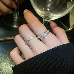 Close-up of elegant open ring set with pearls and oval zircons in warm light