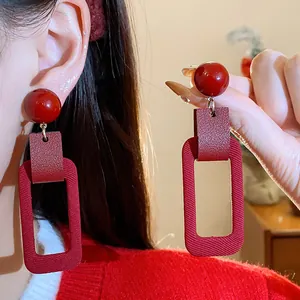 Detail view of retro red geometric rectangular earrings with textured fabric finish