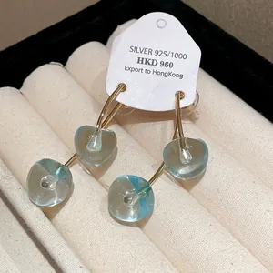 Detailed view of translucent blue resin cherry earrings with 925 silver needles
