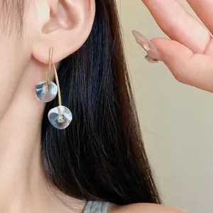 Detailed view of minimalist cherry resin drop earrings with gold stems worn on ear