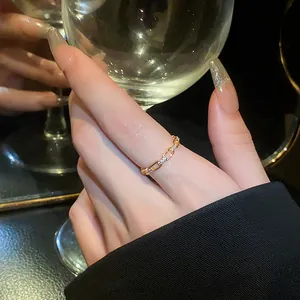 Close-up detail of an elegant gold oval chain link ring adorned with sparkling zircons.
