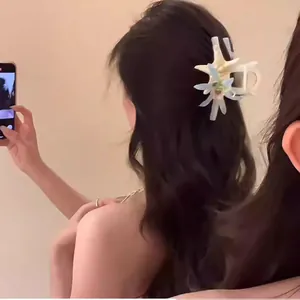 Close-up of a sweet starfish flower claw clip styled in a girl's long wavy hair