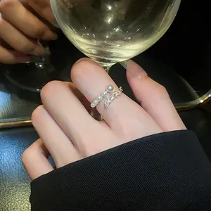 Detailed view of an elegant open ring with white pearls and sparkling oval zircons