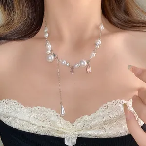 Elegant pearl necklace with rhinestone accents and a pink teardrop pendant charm