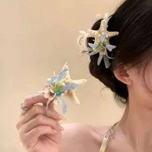 Detailed view of beach-themed starfish hair claw clip with floral decoration and blue rhinestone