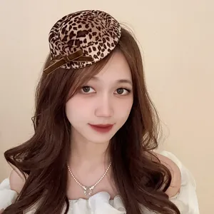 Modella con mini cappello fascinator leopardato vintage e fiocco di velluto marrone