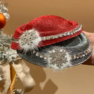 Primo piano di fermagli per capelli natalizi glitterati rossi e argento con fiocchi di neve.