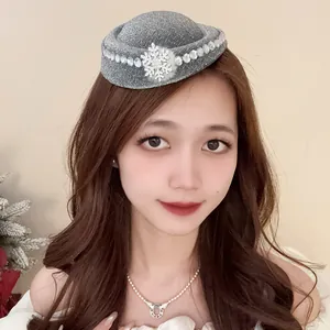 Primo piano di un cappello pillbox grigio glitterato con fiocco di neve e cristalli