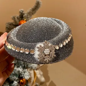 Primo piano di un fermaglio per capelli natalizio glitterato con fiocco di neve e perle