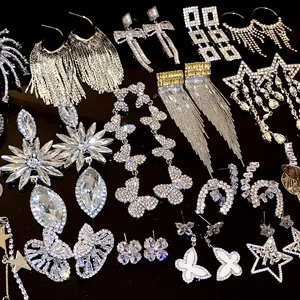 Detailed view of various silver rhinestone earrings with butterfly and star designs