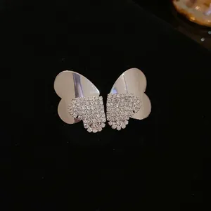 Close-up of elegant butterfly stud earrings featuring pavé crystals in silver finish