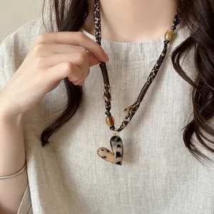 Close-up of a retro leopard print heart pendant necklace with wooden beads