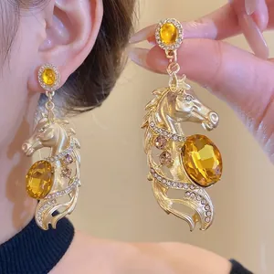 Vintage gold-tone horse drop earrings with amber yellow oval gemstones and sparkly rhinestones.