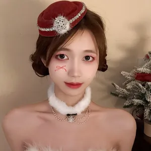 Dettaglio di un set molletta mini cappello di Natale e girocollo bianco di peluche.