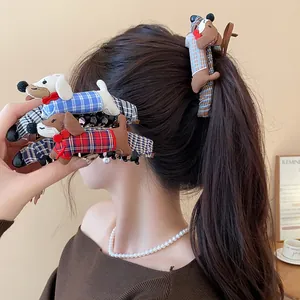 Primer plano de lindas pinzas para el cabello de tela con forma de perro salchicha a cuadros