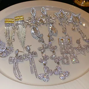 Collection of luxury silver needle drop earrings with sparkling rhinestones in various shapes.