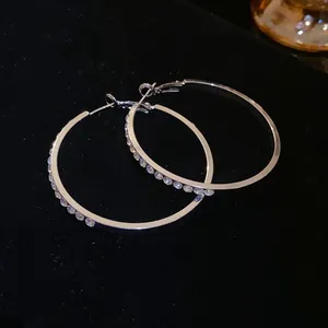 Detailed macro view of elegant silver hoop earrings encrusted with sparkling clear rhinestones