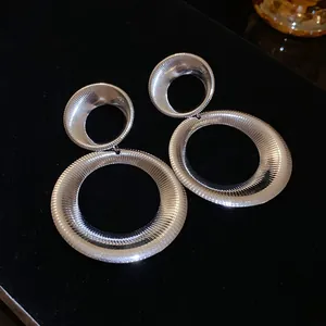 Detailed view of silver-toned double hoop earrings with textured concentric line pattern