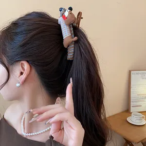 Detalle de un lindo clip de pelo de peluche de perro salchicha en una coleta alta.
