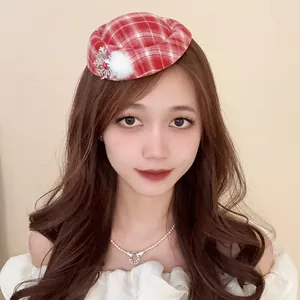 Primo piano di una modella che indossa un mini cappello natalizio a quadri rossi