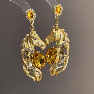 Macro detail of vintage gold-plated horse head earrings with amber crystals and rhinestones