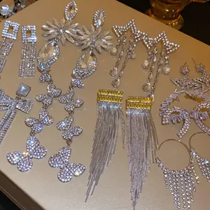 Detailed view of various sparkling rhinestone butterfly and star tassel earrings