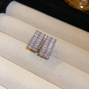 Macro detail of silver rectangular stud earrings with shimmering baguette zirconia.