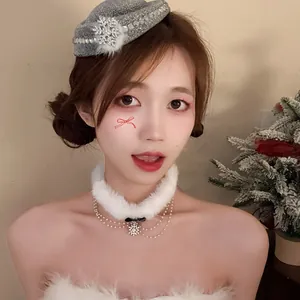 Elegante girocollo natalizio in finta pelliccia bianca e berretto con fiocco di neve su modella
