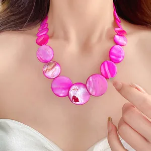 Detailed close-up of pink shell disc necklace on model showing iridescent texture