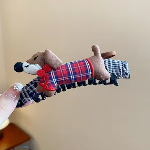 Detalle de una linda pinza para el pelo de tela de perro salchicha con lazo de cuadros rojo