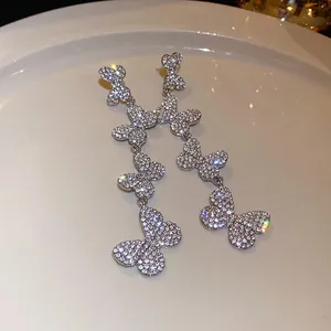 Detailed macro view of elegant long butterfly earrings featuring sparkling rhinestone pavé