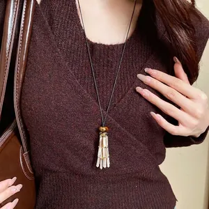 Vintage leather rope necklace with a shell tassel pendant shown on a model's neck