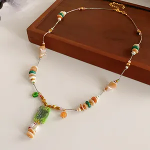 Close-up of vintage beaded necklace with green stone pendant and mixed beads