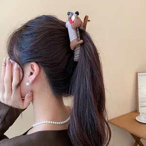 Primer plano de una linda pinza para el cabello de perro salchicha de tela para un estilo.