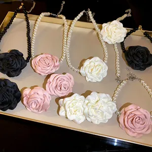 Französischer Stil Perlenketten und Armbänder mit Stoffrosen auf einem goldenen Tablett