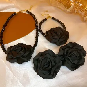 Detail eines französischen Vintage-Schmucksets mit schwarzen Stoffrosen und Perlenkette