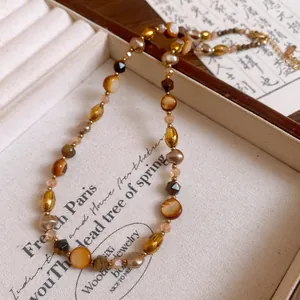 Detailed view of vintage Maillard style beaded necklace in earthy tones and gold.
