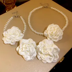 Detailansicht des Sets aus Halskette und Armband mit weißen Stoffblumen und Perlen
