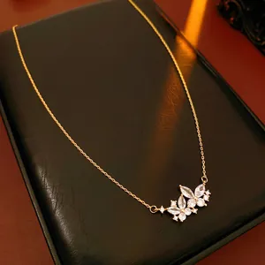 Close-up of vintage golden butterfly necklace with white zircon on black display box