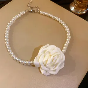 Detailansicht eines eleganten Perlen-Chokers im französischen Stil mit weißer Stoffrose