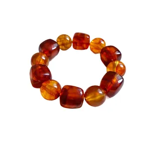 Vintage irregular geometric acrylic beaded bracelet with amber tones on white backdrop