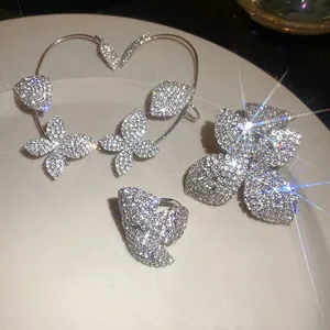 Vista detallada de un conjunto de joyas de lujo con ear cuff de mariposa y pedrería