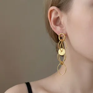 Detailed close-up view of elegant gold hollow geometric dangling earrings worn on ear