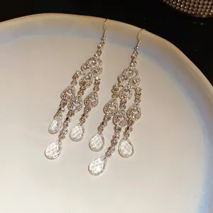 Detailed view of hollow rhinestone tassel earrings with crystal water drop charms.