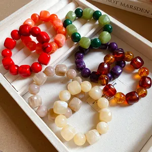 Close-up of colorful acrylic beaded bracelets with irregular geometric shapes in a jewelry tray.